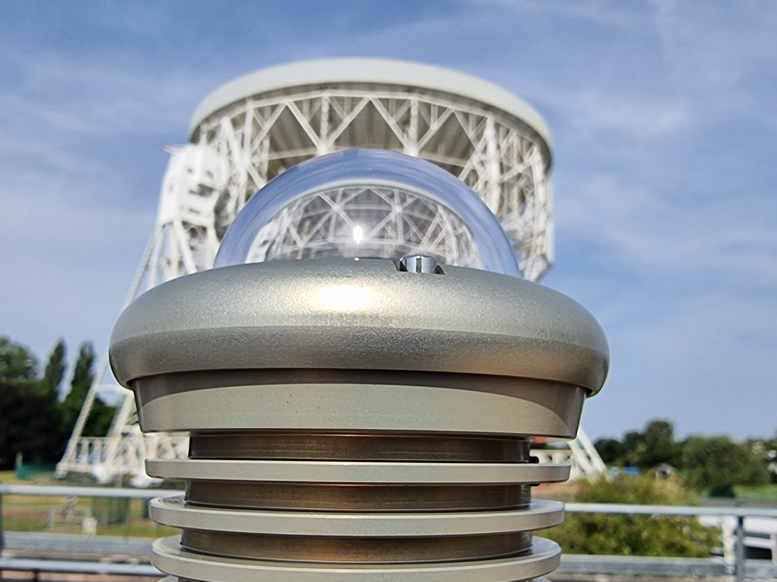 View of the Lovell Telescop at Jodrell Bank behind (and through the transparent protective dome of) the all-sky camera. 